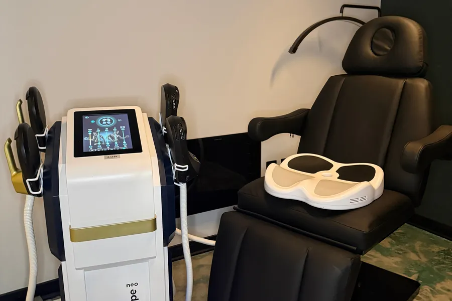The EMShape neo unit beside a treatment recliner with the pelvic floor pad on the seat